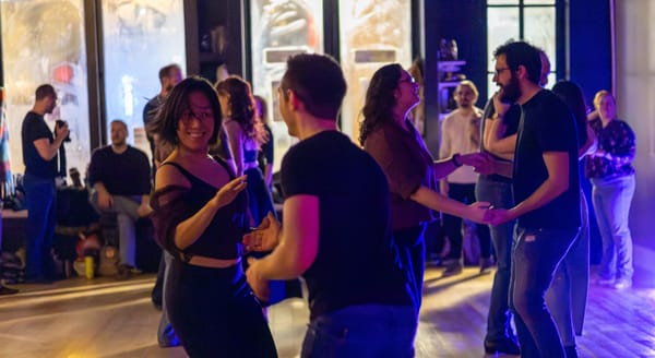 Groups of people fusion dancing with a woman smiling